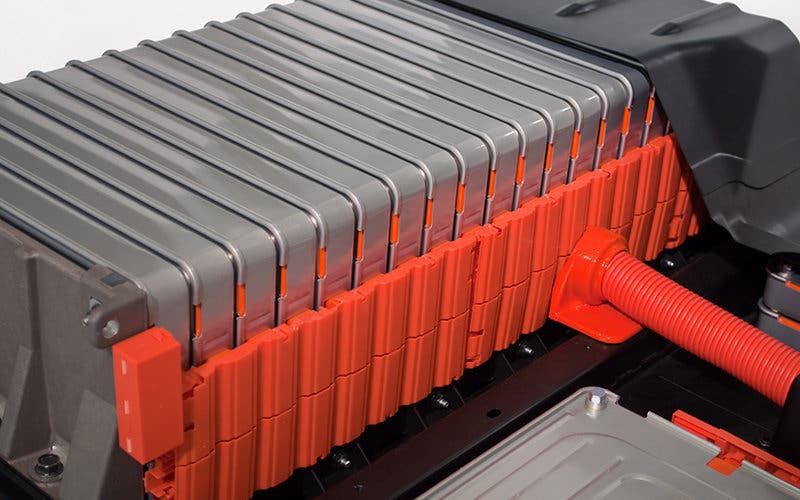 Batteries loaded in a row on an electric car. Each battery pack is stacked in an orange plastic case.