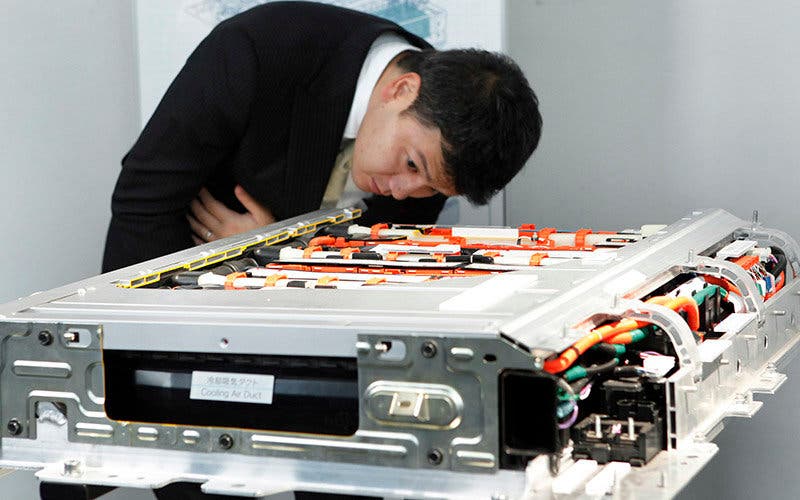 A man examines a lithium-ion battery for Toyota Motor Corp.'s Prius plug-in hybrid vehicle during the unveiling in Tokyo, Japan, on Tuesday, Nov. 29, 2011.  Photographer: Kiyoshi Ota/Bloomberg