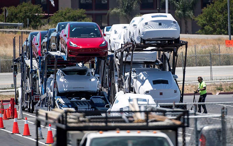 Tesla Motors Inc.'s vehicles are loaded onto a car hauler at the company's production plant in Fremont, California, U.S., on Wednesday, June 20, 2018. Elon Musk, Tesla's chief executive officer, said the company needed another general assembly line to reach its production targets for the Model 3. "A new building was impossible, so we built a giant tent in 2 weeks," Musk said on Twitter. Photographer: David Paul Morris/Bloomberg