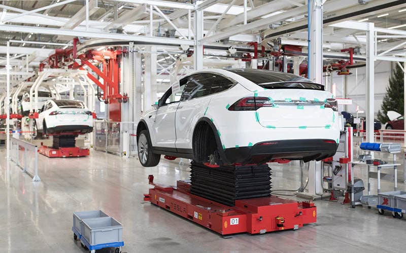 Tesla Model X sports utility vehicles (SUV) stand on hydraulic platforms during assembly for the European market at the Tesla Motors Inc. factory in Tilburg, Netherlands, on Friday, Dec. 9, 2016. A boom in electric vehicles made by the likes of Tesla could erode as much as 10 percent of global gasoline demand by 2035, according to the oil industry consultant Wood Mackenzie Ltd. Photographer: Jasper Juinen/Bloomberg via Getty Images