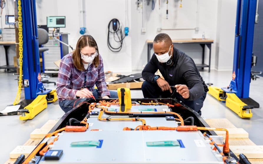 Dane Hardware, Ford Motor Co. design and release engineer, and Mary Fredrick, Ford Motor Co. battery validation engineer, measure the voltage of a battery using a digital multi-meter at Ford’s Battery Benchmarking and Test Laboratory in Allen Park, Michigan. Since this battery is not connected to a test setup, the meter is used to confirm the battery voltage and check isolation.