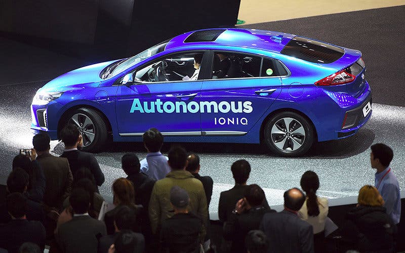 Visitors look at Hyundai Motor's Autonomous Ioniq car during a press preview of the Seoul Motor Show in Goyang, northwest of Seoul, on March 30, 2017. South Korea's largest international auto show will open on March 31, with a total of 27 brands showing their latest cars and concepts. / AFP PHOTO / JUNG Yeon-Je