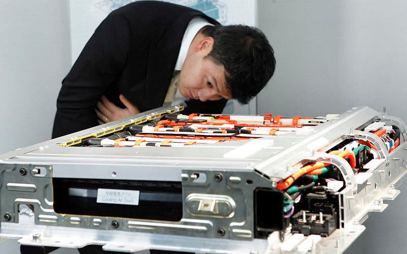 A man examines a lithium-ion battery for Toyota Motor Corp.'s Prius plug-in hybrid vehicle during the unveiling in Tokyo, Japan, on Tuesday, Nov. 29, 2011. Photographer: Kiyoshi Ota/Bloomberg