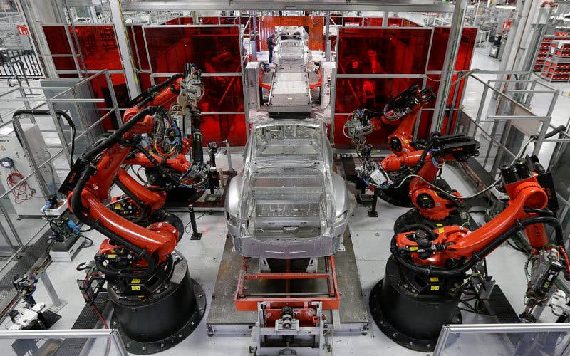 In this May 14, 2015 photo, Kuka robots work on Tesla Model S cars in the Tesla factory in Fremont, Calif. The Institute for Supply Management, a trade group of purchasing managers, issues its index of manufacturing activity for May on Monday, June 1, 2015. (AP Photo/Jeff Chiu)