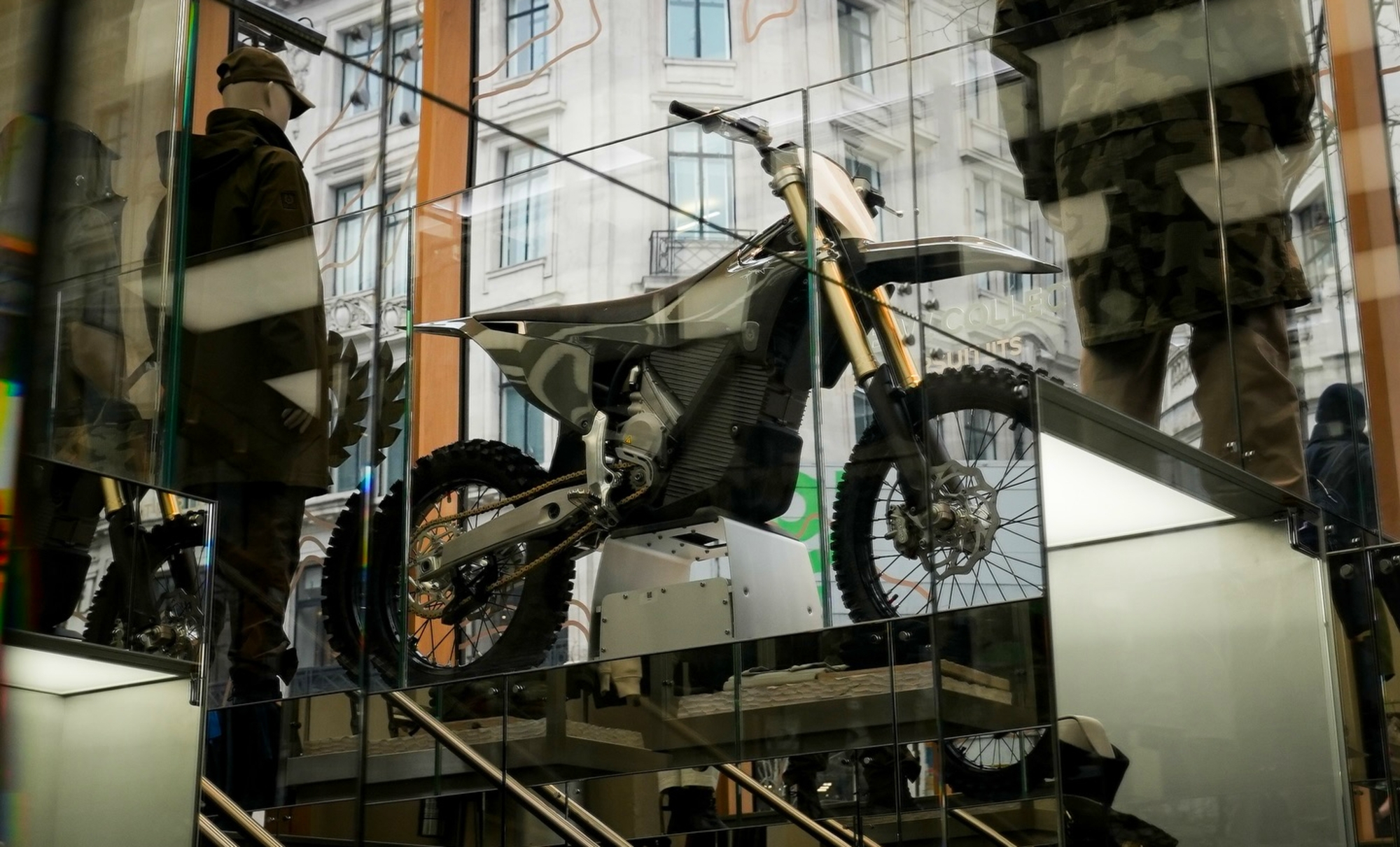 Una moto de cross eléctrica en el escaparte de una prestigiosa firma de ropa.