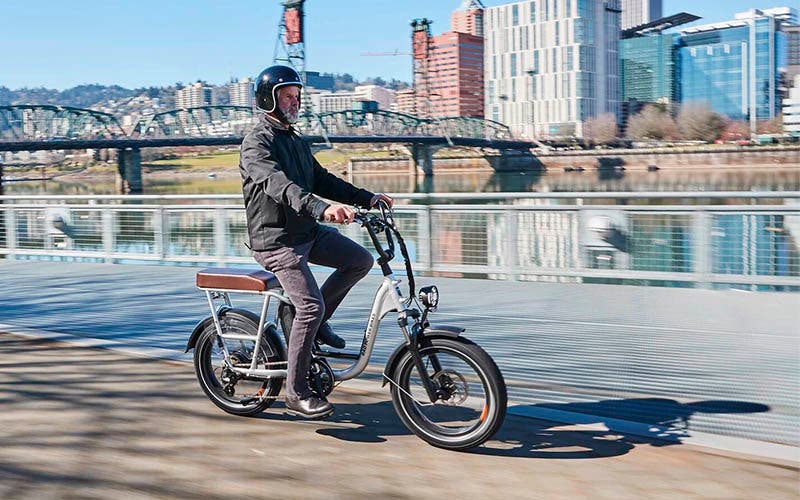  La bicicleta eléctrica RadRunner Plusp con el pack de pasajero, una pantalla LCD, la horquilla de suspensión y los guardabarros. 