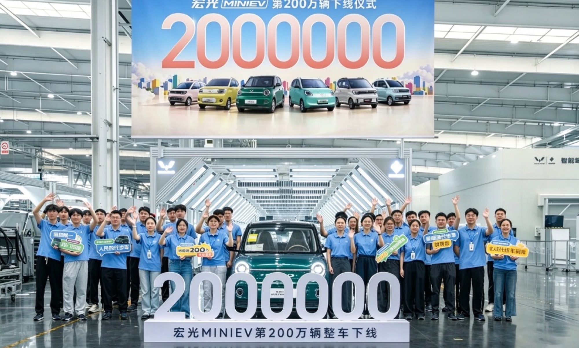 Los trabajadores de la fábrica de Wuling junto al Hongguang Mini EV 2 millones fábricado.