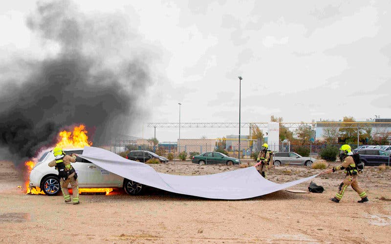  Prueba de extinción de fuego en un coche eléctrico o de hidrógeno con una manta ignífuga. 