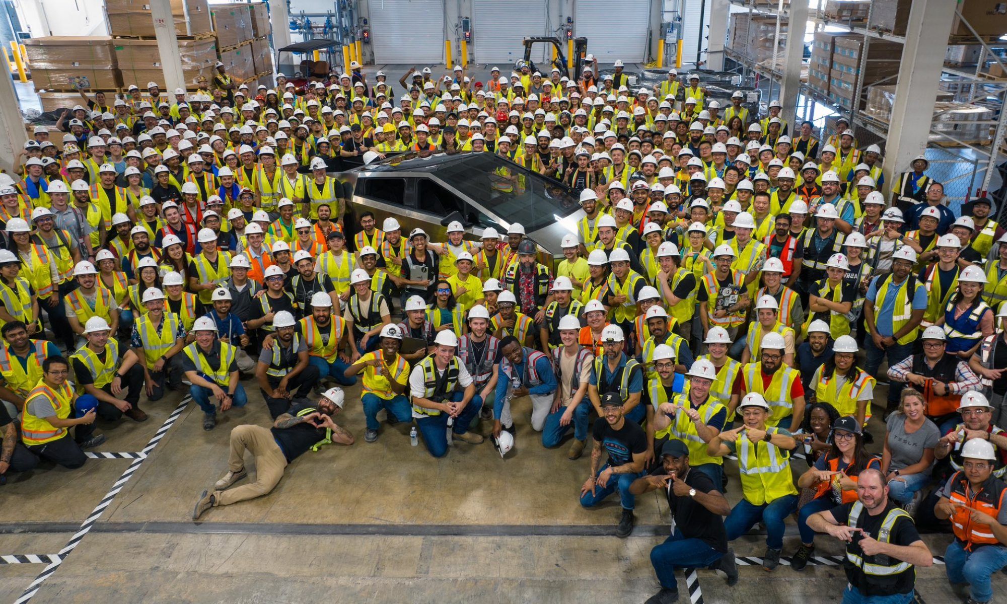 Los trabajadores se reúnen junto a la primera Cybertruck de producción en serie.